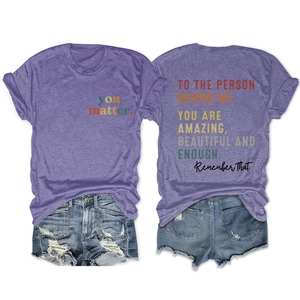 Flat lay of purple short sleeve T-shirt with back text print and distressed denim shorts