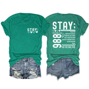 Platliggende groene t-shirt met STAY-tekst en versleten blauwe korte denim broek