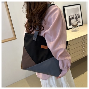 Side view of a tri-color canvas tote bag with leather FASHION patch for daily commute