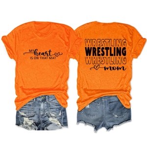 Detail of Wrestling Mom t-shirt featuring vibrant orange fabric and distressed denim shorts
