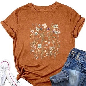 Detail of floral printed orange t-shirt with trendy waist knot and hand-drawn wildflowers