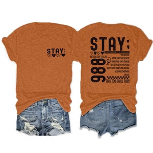 Detail van oranje katoenen T-shirt met opdruk en distressed denim korte broek