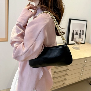 Chic black leather shoulder bag with bold gold chain strap for women, 2024 fashion