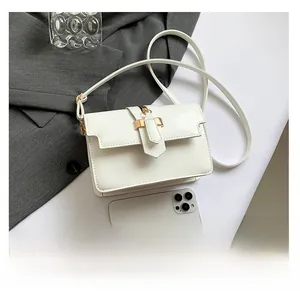 Detailed view of a white leather crossbody bag with a gold metal buckle and phone for scale