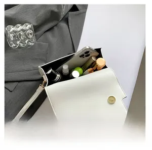 Detailed interior view of white leather crossbody bag showing daily essentials capacity