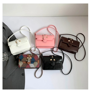 Flat lay of small crossbody bags in five colors with gold buckles and leather straps