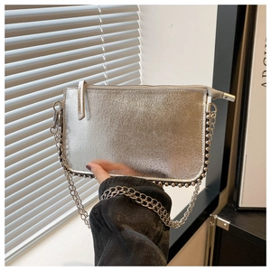 Close-up of silver metallic handbag featuring studded edges and a sleek chain strap