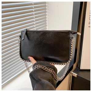 Close-up of black envelope handbag featuring silver bead edges and metallic chain strap