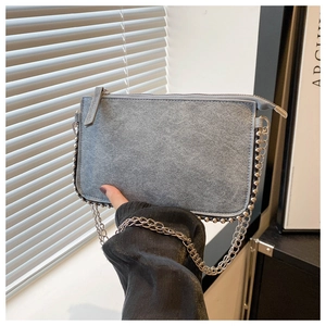 Detail of gray frosted suede envelope bag featuring silver bead trim and metal chain strap