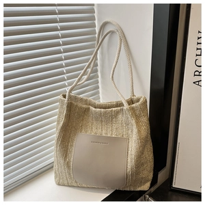 Detail of beige woven tote bag with FASHION & BAGS leather patch and rope handles