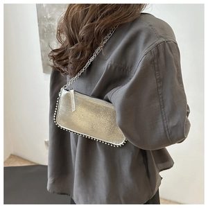 Close-up of silver Y2K shoulder bag with metallic finish and beaded trim detail