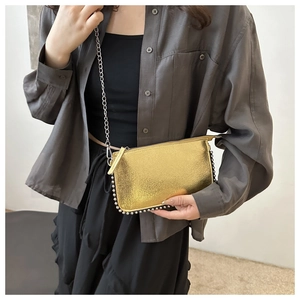 Detail of gold metallic envelope bag with silver bead trim and chain strap