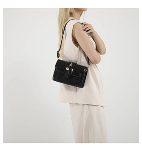Close-up of black textured leather crossbody bag with elegant gold metal hardware and buckle