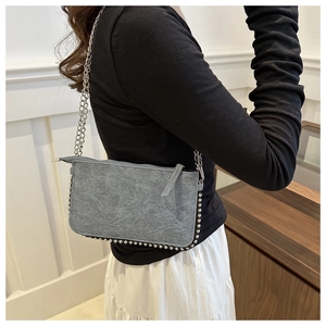 Detail view of the gray faux suede envelope bag featuring metallic beaded edges and chain
