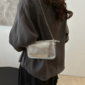 Silver metallic chain envelope bag with studded edges and minimalist industrial style