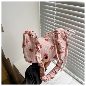 Vue détaillée du sac à bandoulière en velours rose avec motifs fraises et bord à volants