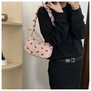 Détail du sac à bandoulière en velours rose avec imprimé fraise et anse plissée