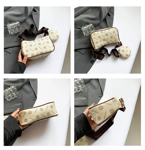 Detail view of two-piece cream floral handbag set with wide strap and gold hardware
