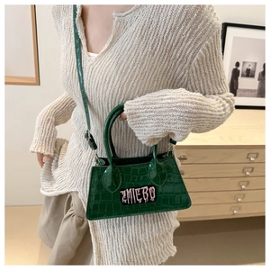 Dark green croc-effect mini handbag styled with beige knitwear and adjustable shoulder strap