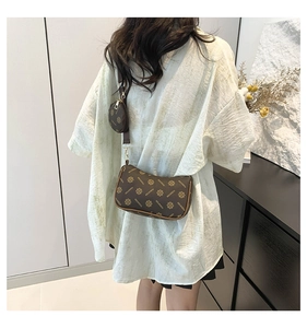 Detail of vintage brown monogram crossbody bag with round pouch and woven strap