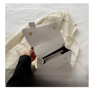 Detailed interior view of white minimalist square bag showing space for a smartphone