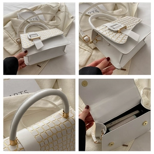 Detail view of white square handbag with golden crocodile texture and metal magnetic clasp