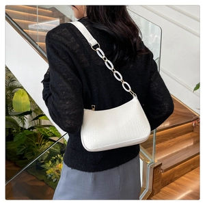 Close-up of white crocodile pattern shoulder bag with chunky acrylic chain strap