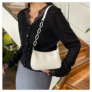 Detail view of white crocodile pattern shoulder bag with matching thick chain strap