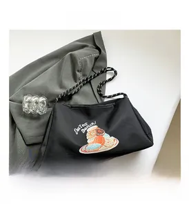 Détail du sac cabas noir avec imprimé donut et bandoulière en corde noire et blanche