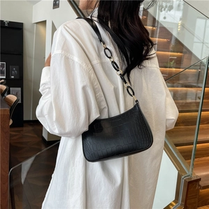 Chic black crocodile embossed underarm bag with gold chain strap on shoulder