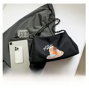 Détail du sac cabas en nylon noir avec broderie donut et bandoulière en corde tressée
