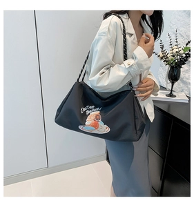 Détail du sac cabas noir avec imprimé donuts et anses en corde à pois blancs