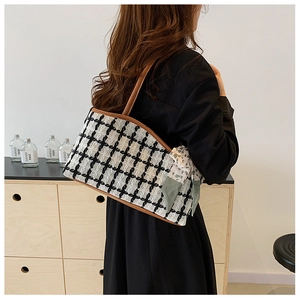 Detail of checkered tote bag with brown straps and green floral scarf on model