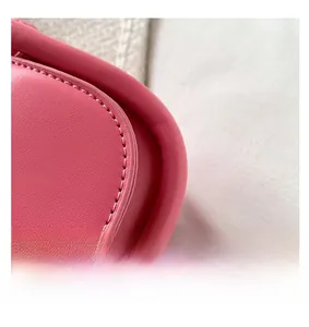 Detail shot of deep pink lychee texture leather with uniform double stitching on edges