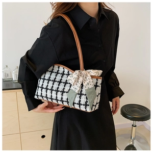 Detail of checkered tote bag featuring a decorative leopard silk scarf and brown leather handles
