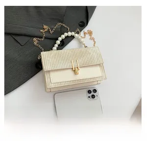Détail du sac à main en paille avec poignée en perles et chaîne pour référence de taille