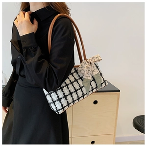 Détail du sac cabas en tweed à carreaux avec nœud en soie et bandoulière en cuir brun
