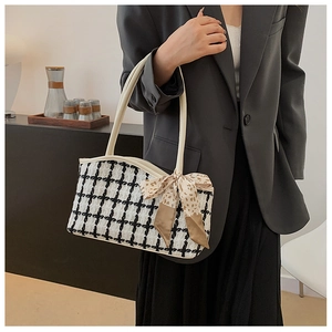 Detail of tweed checkerboard tote bag featuring a leather strap and leopard silk scarf
