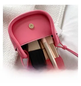 Pink faux leather mini bag interior showing capacity for three lipsticks with magnetic snap