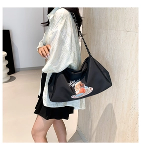 Détail du sac noir avec imprimé donut et bandoulière en corde tissée stylée
