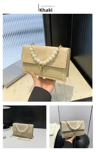 Détail du sac en paille kaki avec grande poignée en perles et fermoir en métal doré