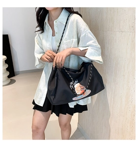 Détail du sac cabas noir avec imprimé glace et bandoulière tissée contrastée
