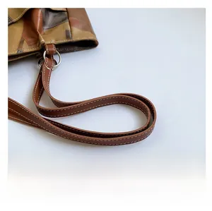 Detail of contrast color leather tote with thick shoulder strap and white stitching