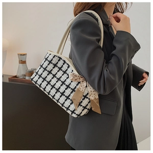 Detail of checkered tote bag featuring an elegant leopard print scarf on leather handles