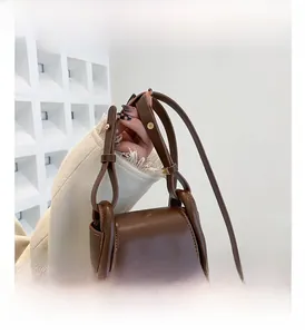 Detailed close-up of dark brown mini leather handbag with stylish flap and metal buckle