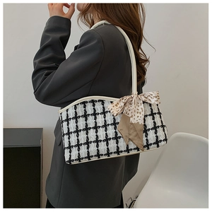 Détail du sac cabas à carreaux avec un nœud décoratif léopard et une texture en tweed