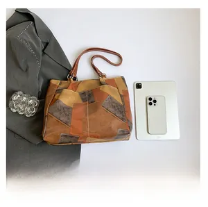 Detail of color-block leather tote bag featuring contrast stitching and large capacity