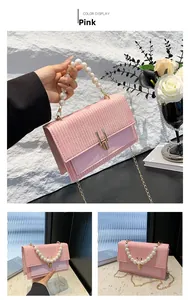 Détail du sac bandoulière tissé rose avec une grande poignée en perles et chaîne dorée