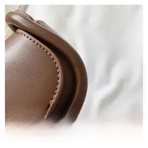 Detail of premium brown leather texture and precision stitching on the vintage child handbag
