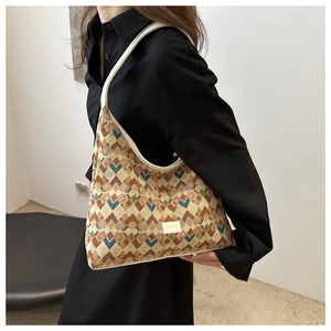 Detail showing retro geometric pattern shoulder bag with cream leather trim and handle